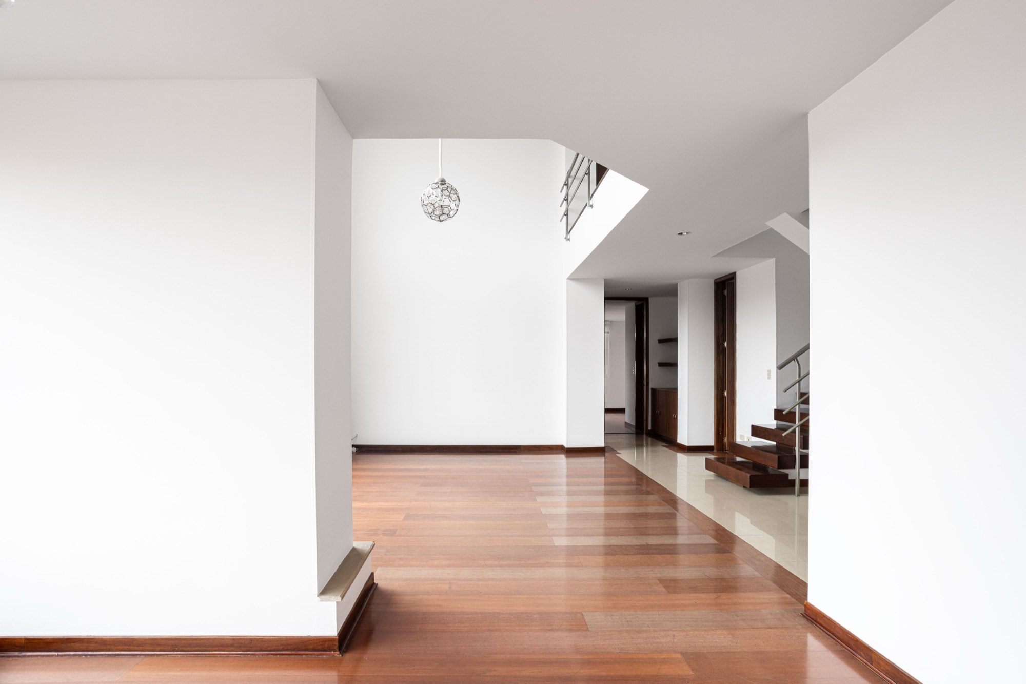 Vivienda reformada integral con suelo de madera y paredes blancas